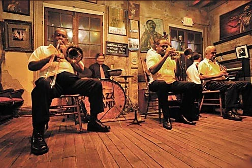Preservation Hall Jazz Band performing live in New Orleans with musicians playing brass instruments in historic jazz venue