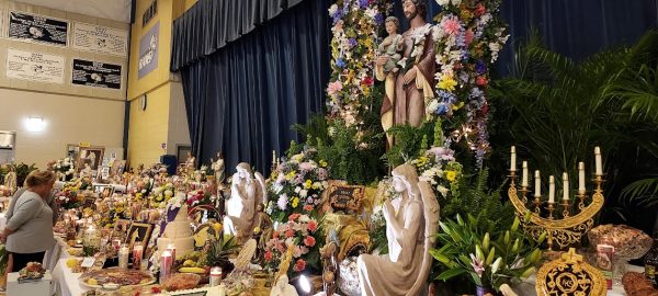 Saint Joseph altar display in New Orleans with flowers candles statues and traditional Italian Catholic food offerings