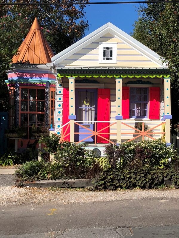 colorful shotgun house in New Orleans featuring vibrant facade decorative trim and traditional narrow architectural design