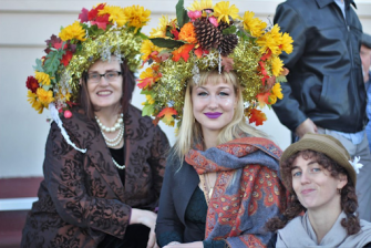 women wearing elaborate decorative hats at New Orleans Fair Grounds Thanksgiving horse racing tradition featuring festive costumes and social gathering