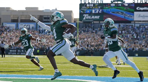 Tulane Green Wave football players celebrating a touchdown during college game at Yulman Stadium in New Orleans.